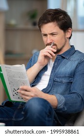 Young Man Sitting Doing A Crossword Puzzle