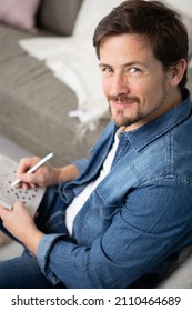 Young Man Sitting Doing A Crossword Puzzle