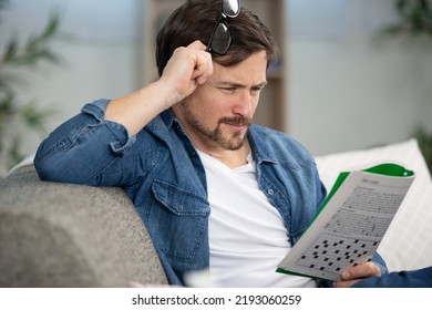 Young Man Sitting Doing A Crossword Puzzle