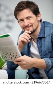 Young Man Sitting Doing A Crossword Puzzle