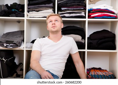 Young Man Sitting In Front Of His Wardrobe	. 