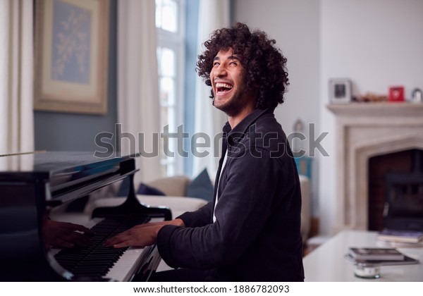 Young Man\
Sitting At Grand Piano And Playing At\
Home