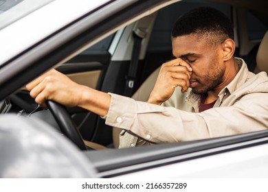 Young man sitting inside his car and feeling stressed and upset - Powered by Shutterstock