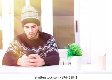 Young man sitting in the office using the mobile phone