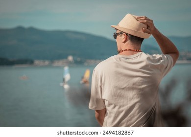 young man sitting on the beach looking at the sea - Powered by Shutterstock