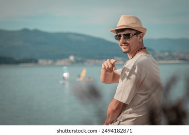 young man sitting on the beach in front of the sea pointing with his finger - Powered by Shutterstock