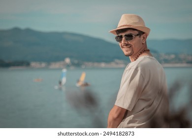 young man sitting on the beach facing the sea - Powered by Shutterstock