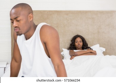 Young man sitting on bed after an argument in the bedroom