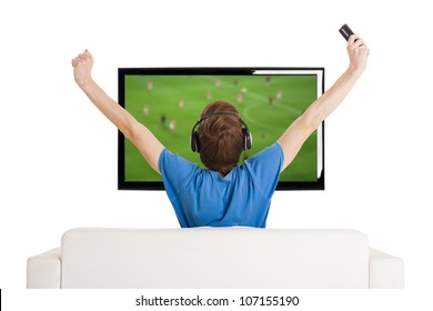 Young Man Sitting On The Couch Watching A Football Game On Tv With Arms Up