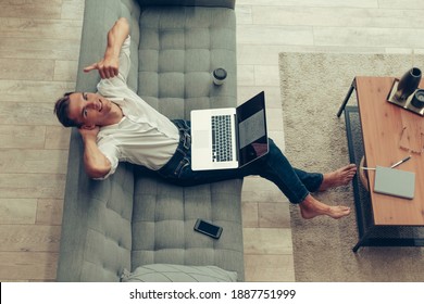 Young Man Sitting On The Couch And Giving A Thumbs Up.