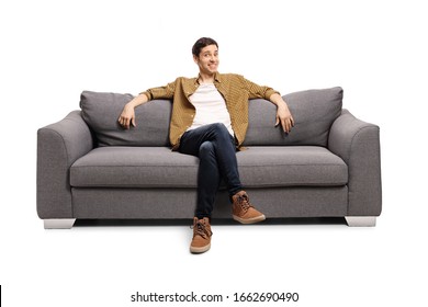 Young man sitting on a gray sofa isolated on white background