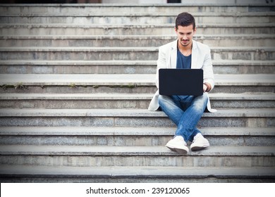 Junge Mann, die mit Laptop auf der Treppe saß