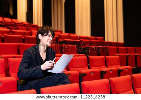 young man sitting on theater seat.