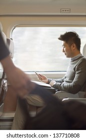 Young man sitting on a train using his phone