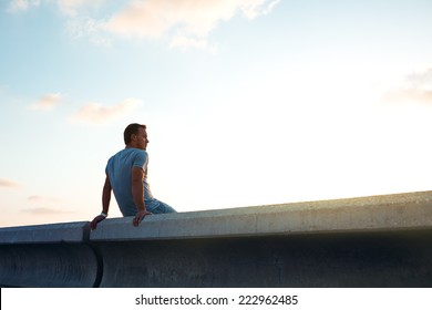 young man sitting at sunset 