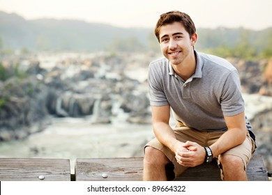 Young man sitting at a waterfall park in Great Falls Virginia - Powered by Shutterstock