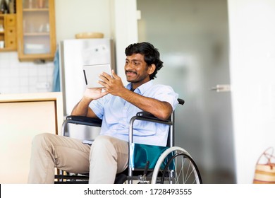 young man sitting in wheelchair with tablet - Powered by Shutterstock