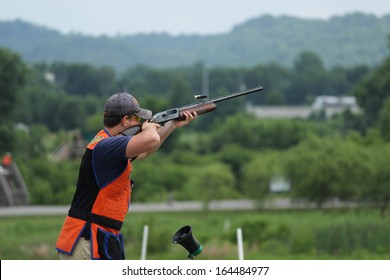 Young Man Skeet Shooting With Airborne Shell