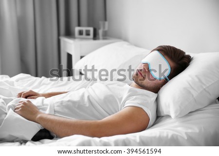 Young Man Sleeping With Blindfold In Bed At Home Young Man Sleeping With Blindfold In Bed At Home