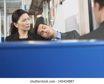 Young man sleeping on businesswoman's shoulder in the train - Powered by Shutterstock