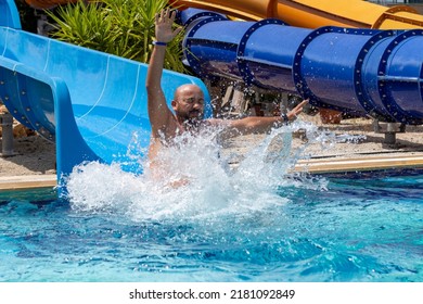 Young man sliding down the water slide. water park, aquapark slides.