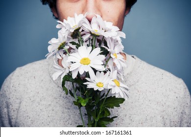 Young Man Smelling A Bouquet Of Flowers