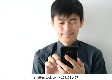 young man smiled happily and he used the smartphone application. - Powered by Shutterstock