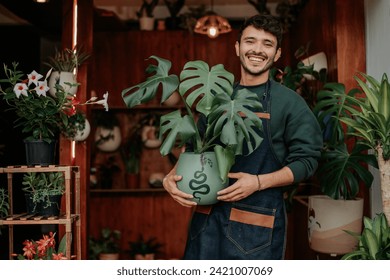 Young man smiles in plant store.
concept: small plant and nursery business. - Powered by Shutterstock