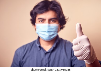 A Young Man Smiles While Wearing Nitrile Gloves With A Surgical Mask On His Face. Long Hair Man. 