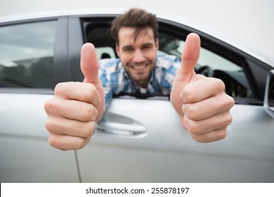 Young Man Smiling At Camera Showing Thumbs Up In His Car