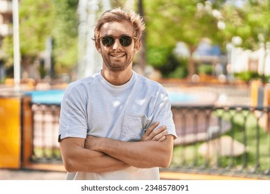 Young man smiling confident standing with arms crossed gesture at park - Powered by Shutterstock