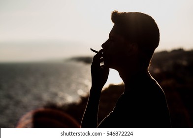 Young Man Smoking Cannabis On The Sea Background