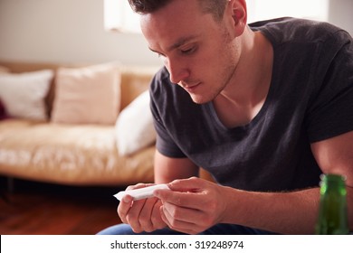 Young Man Smoking Marijuana At Home