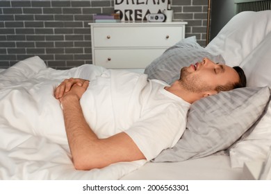 Young man snoring while sleeping in bed. Apnea problem