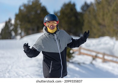 Young Man Snowboarding On The Slopes Of A Ski Resort.