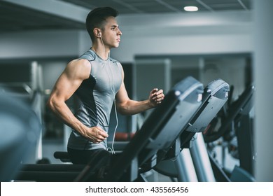 Young man in sportswear running on treadmill at gym - Shutterstock ID 435565456