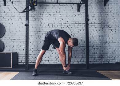 Young Man In Sportswear Stretching Before Training In Gym