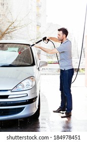 Young Man Spraying His Car Clean