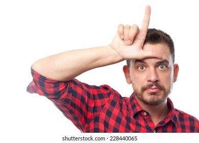 Young Man With Squares Shirt Over White Background. Doing A Loser Symbol With His Hand