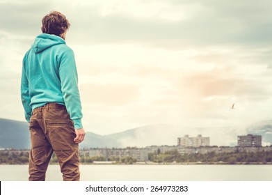 Young Man Standing Alone Outdoor Travel Lifestyle Concept With Lake And City On Background