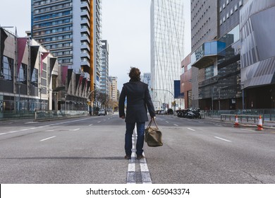 Young Man Standing Alone In The Street Posing With A Bag