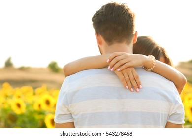 Young Man Standing Back And Girl Hugging His Neck