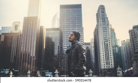 A young man standing with beautiful buildings background before sunset at Chicago city : films grain concept