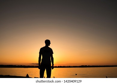 The young man is standing before the river bank with yellow Sunrise or sunset!! - Shutterstock ID 1420409129