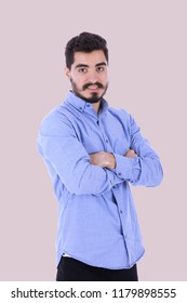 Young man standing with crossed arms smiling on light pink background. - Shutterstock ID 1179898555