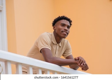 Young man standing on balcony and staring ahead