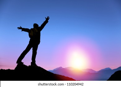 Young Man Standing On The Top Of Mountain And  Watching The Sunrise