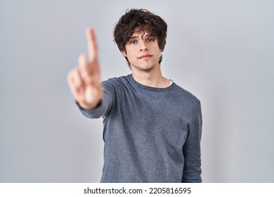 Young Man Standing Over Isolated Background Pointing With Finger Up And Angry Expression, Showing No Gesture 