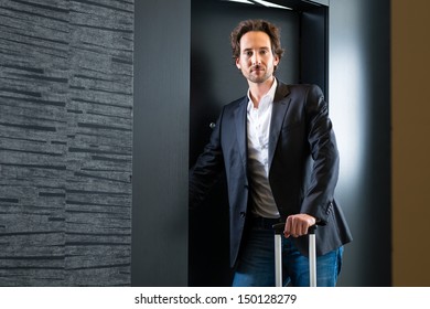 Young Man Standing With A Trolley In Front Of A Room Door In A Hotel