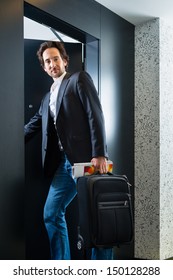 Young Man Standing With A Trolley In Front Of A Room Door In A Hotel